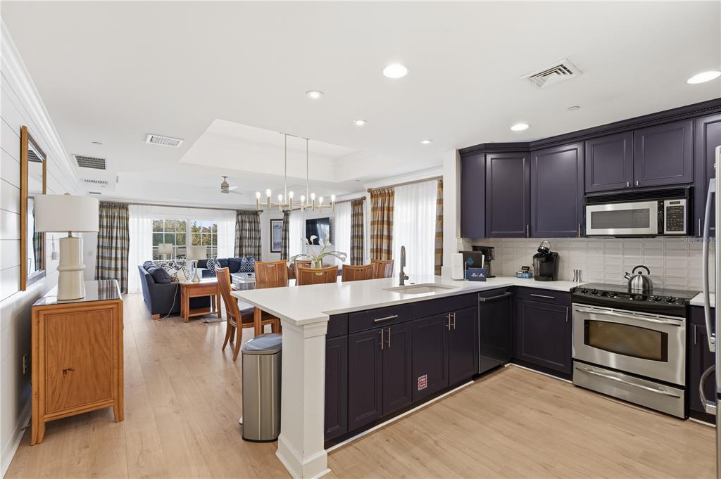 1354 Centre Ct Ridge Drive, Unit 204 Reunion, FL 34747 - Photo 5 of 46 a kitchen with stainless steel appliances granite countertop wooden cabinets a sink dishwasher a stove and a refrigerator with wooden floor
