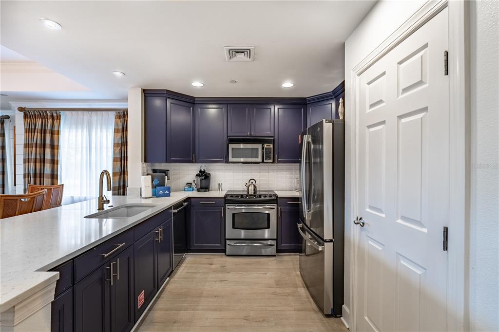 1354 Centre Ct Ridge Drive, Unit 204 Reunion, FL 34747 - Photo 9 of 46 a kitchen with stainless steel appliances granite countertop refrigerator a sink a stove top oven and a center island