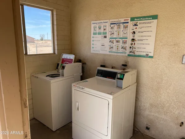 a view of washer and dryer with bathroom in the background