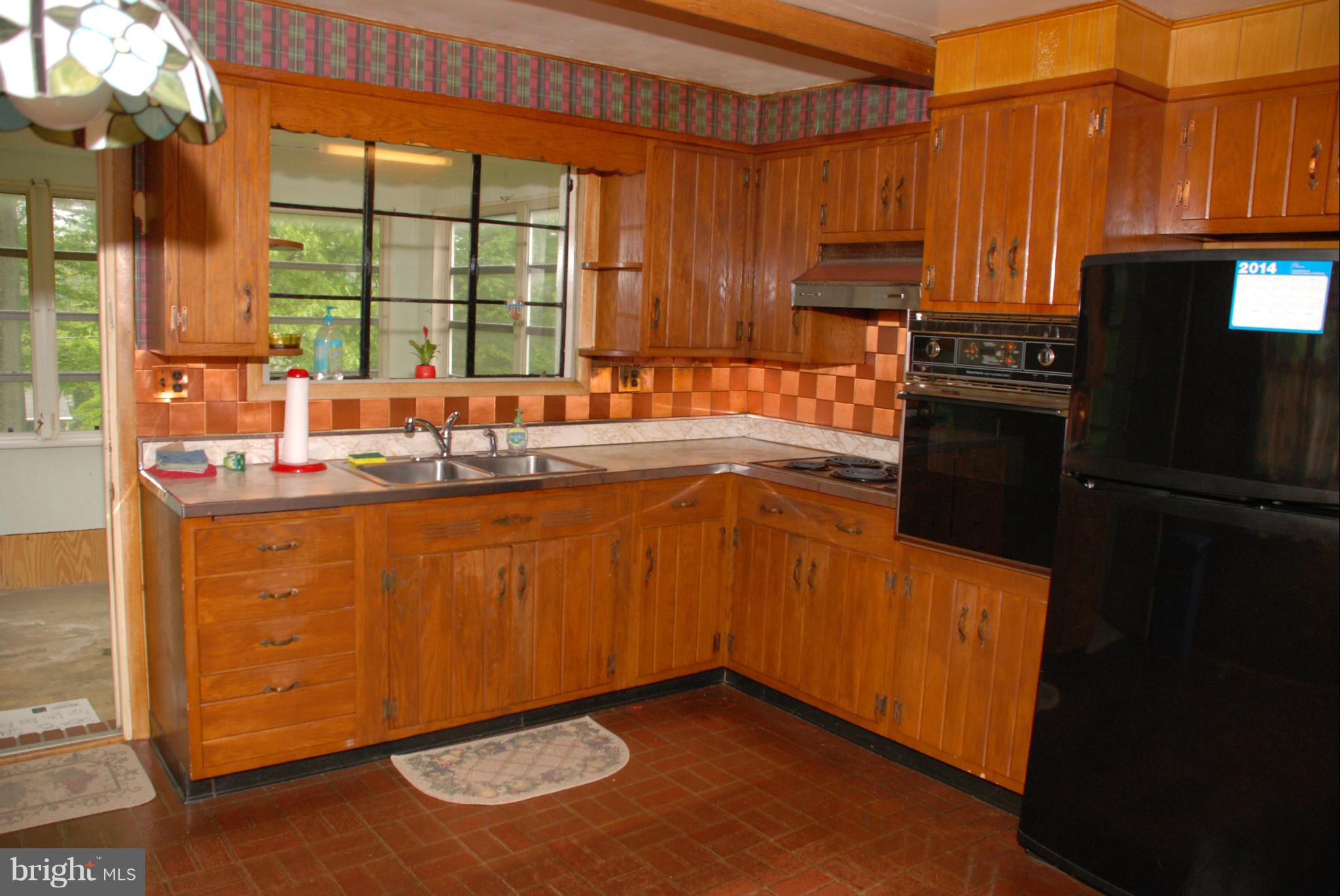 239 Gralan Road Baltimore, MD 21228 - Photo 4 of 21 a kitchen with granite countertop stainless steel appliances a sink a refrigerator a stove a microwave and cabinets