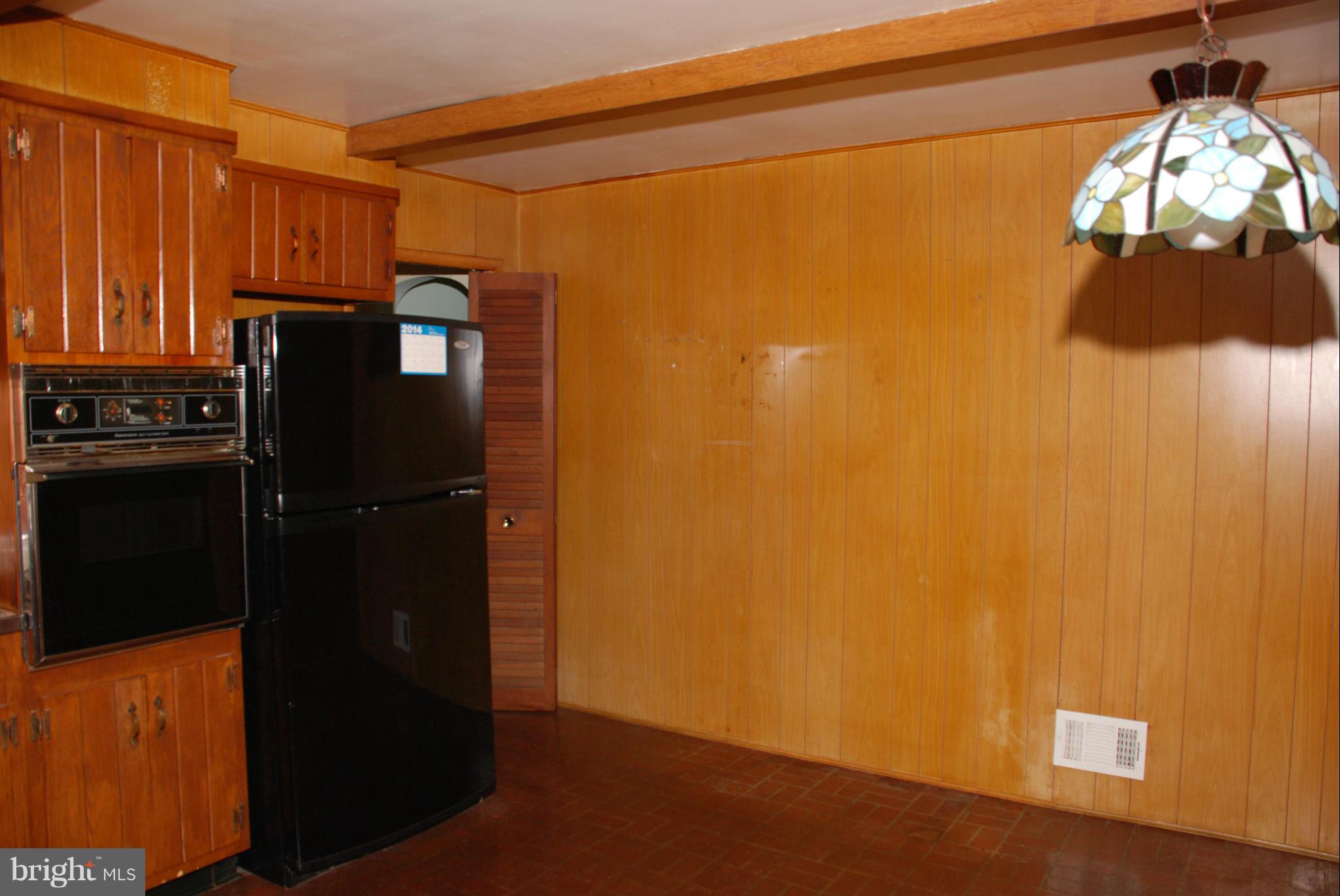239 Gralan Road Baltimore, MD 21228 - Photo 6 of 21 a kitchen with a refrigerator and cabinets