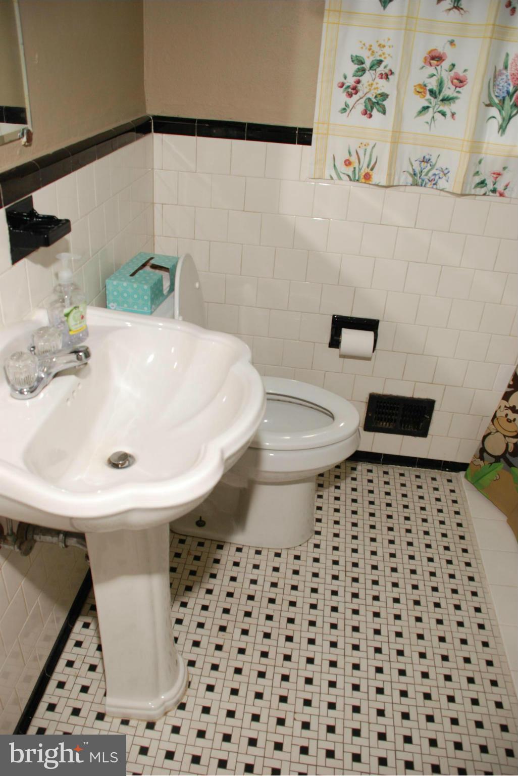 239 Gralan Road Baltimore, MD 21228 - Photo 8 of 21 a bathroom with a sink a toilet and a shower curtain