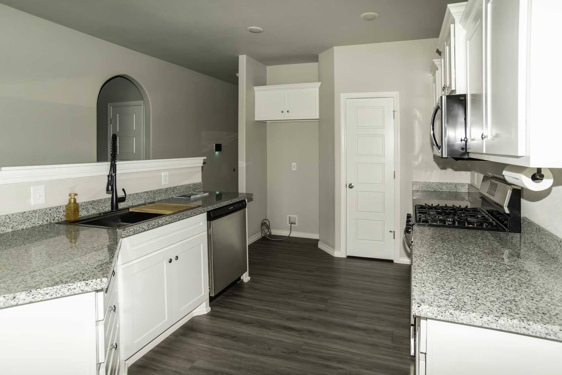 7012 12th Street Lubbock, TX 79416 - Photo 7 of 15 a kitchen with granite countertop a refrigerator and a sink