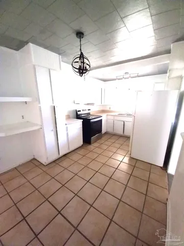 a kitchen with a sink a refrigerator and cabinetry