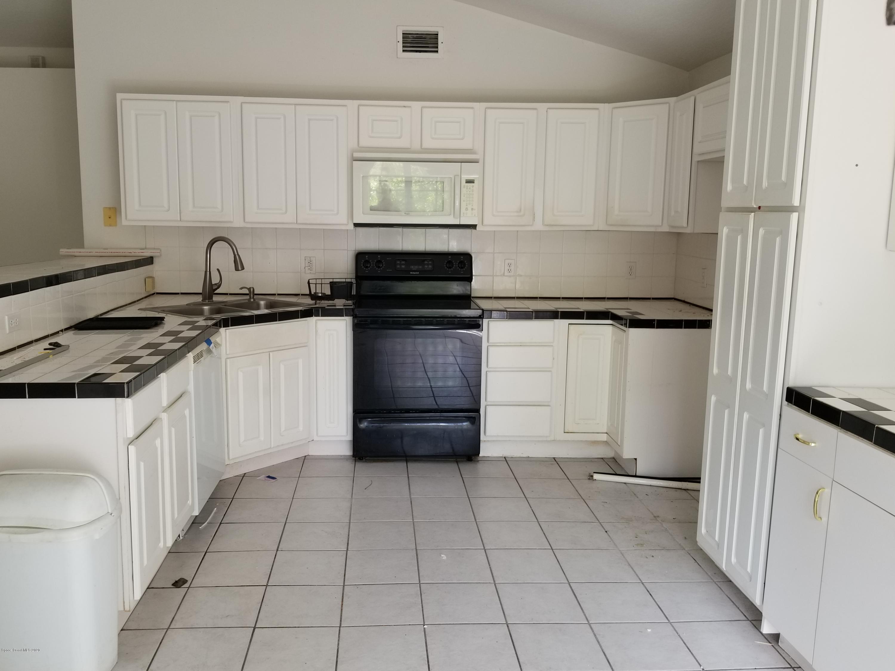 1298 Southwest Malabar Road Palm Bay, FL 32908 - Photo 5 of 9 a kitchen with stainless steel appliances granite countertop a stove a sink and a refrigerator