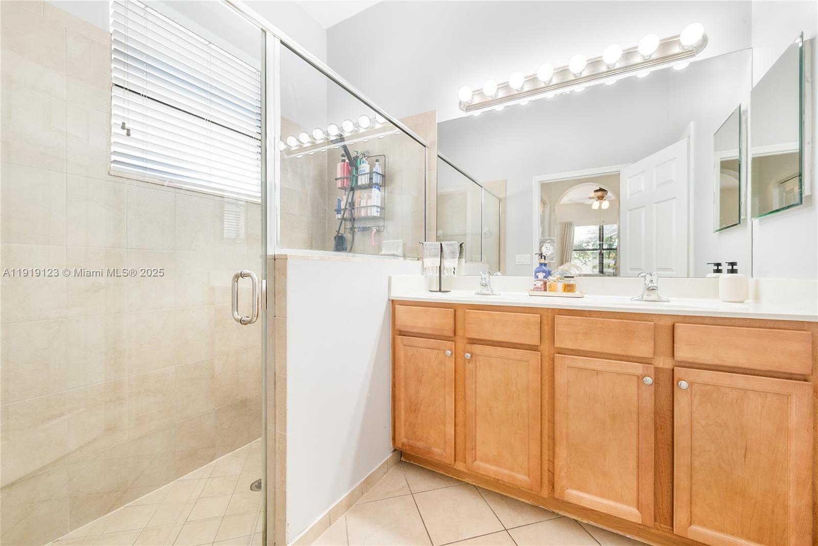 3550 West 86th Terrace, Unit 3550 Hialeah, FL 33018 - Photo 12 of 17 a bathroom with a double vanity sink a mirror a shower and a bathtub