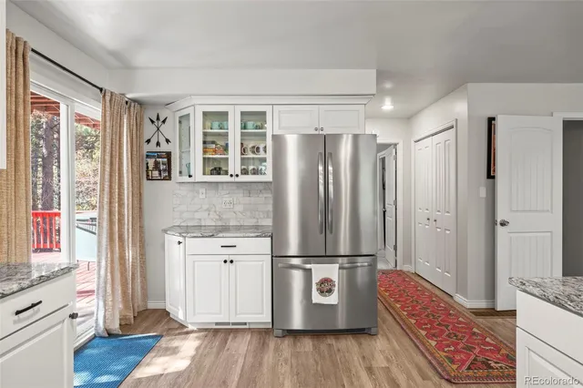 a kitchen with a refrigerator sink and wooden floor