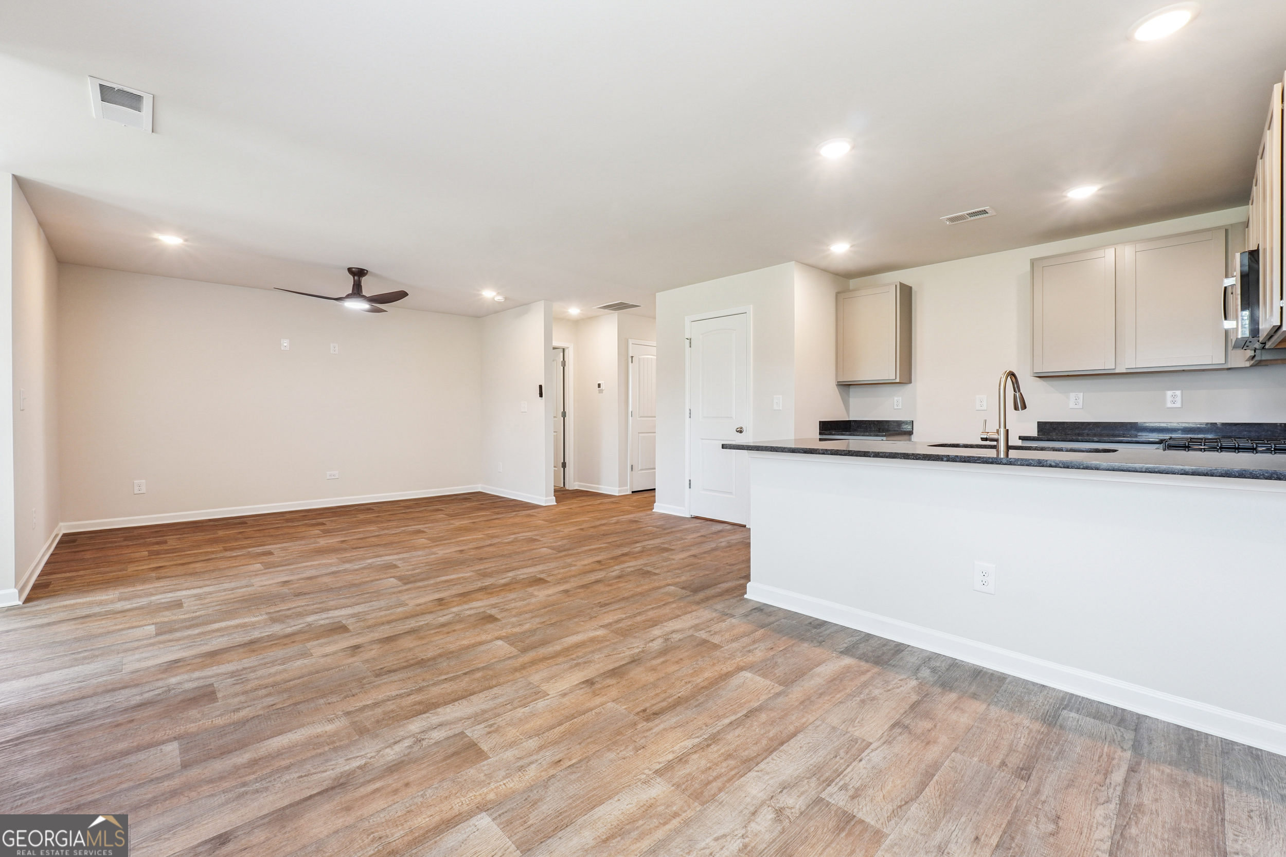 210 Harris Walk, Unit 79 Cataula, GA 31804 - Photo 3 of 22 a view of a kitchen with kitchen island a sink wooden floor and stainless steel appliances