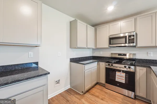 a kitchen with granite countertop wooden cabinets and stainless steel appliances