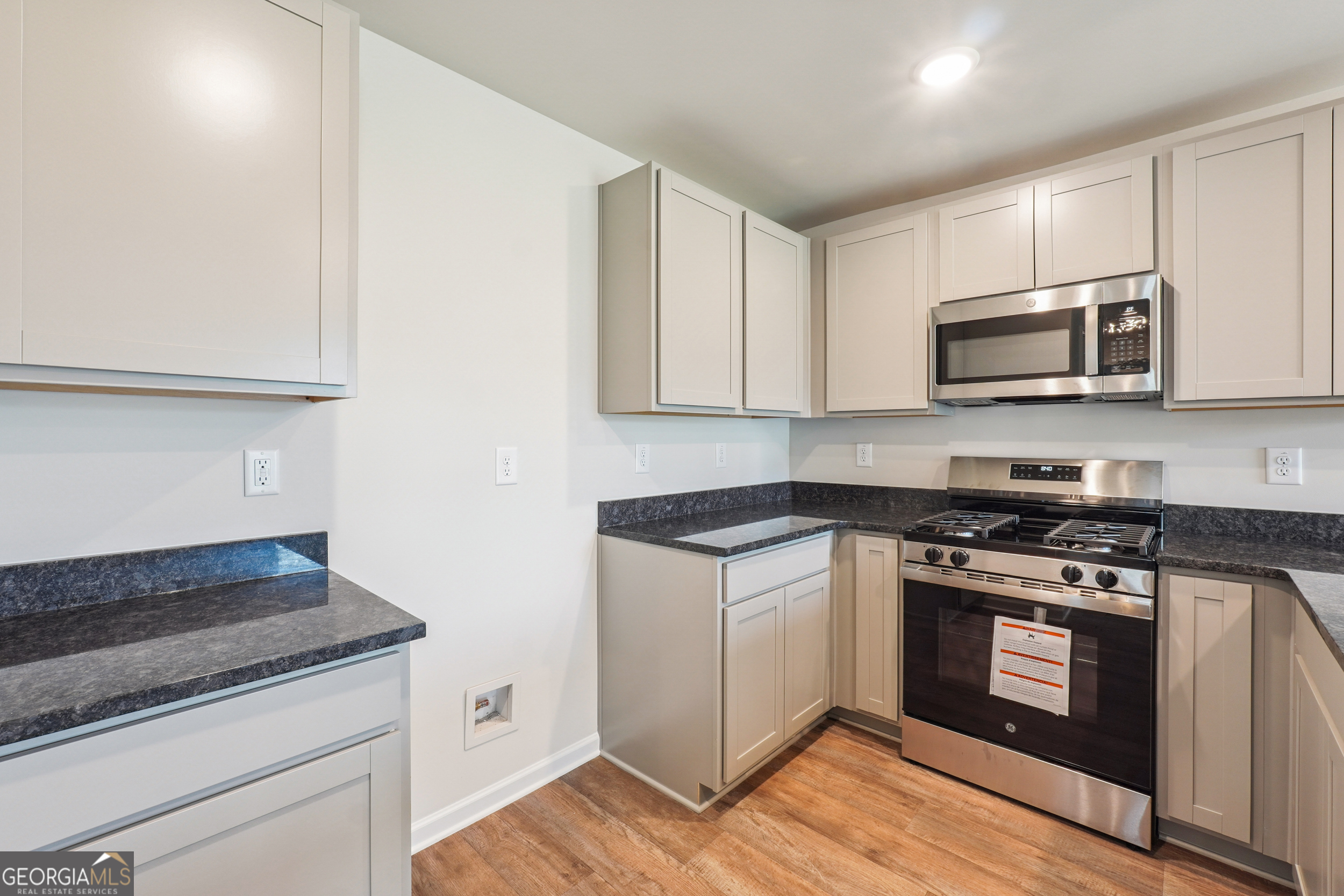 210 Harris Walk, Unit 79 Cataula, GA 31804 - Photo 6 of 22 a kitchen with granite countertop wooden cabinets and stainless steel appliances