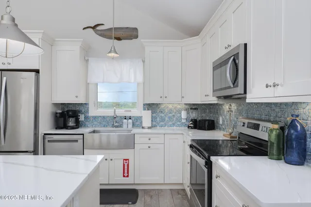 a view of a dining room and livingroom with furniture wooden floor a chandelier