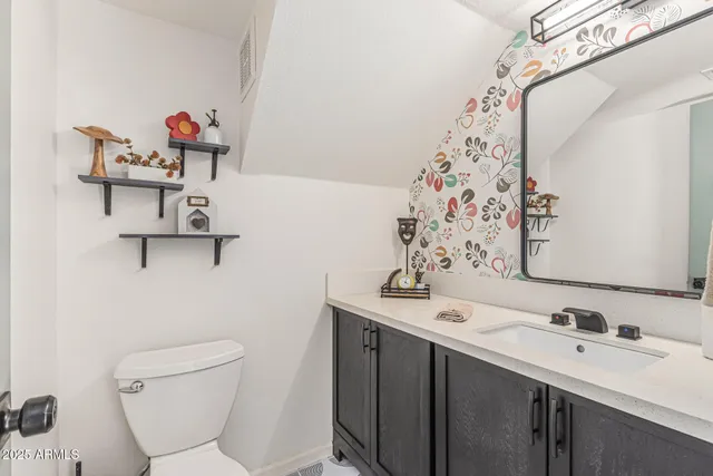 a bathroom with a sink mirror and toilet