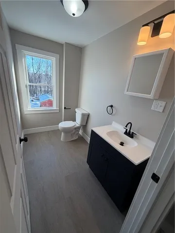 a bathroom with a sink vanity mirror and toilet