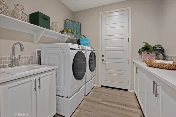 a utility room with sink dryer and washer