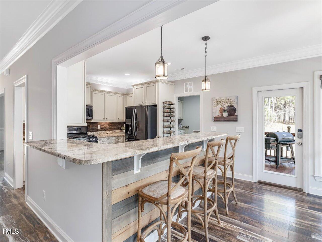 406 Gum Springs Church Road Moncure, NC 27559 - Photo 27 of 100 a kitchen with stainless steel appliances kitchen island granite countertop a dining table chairs and white cabinets