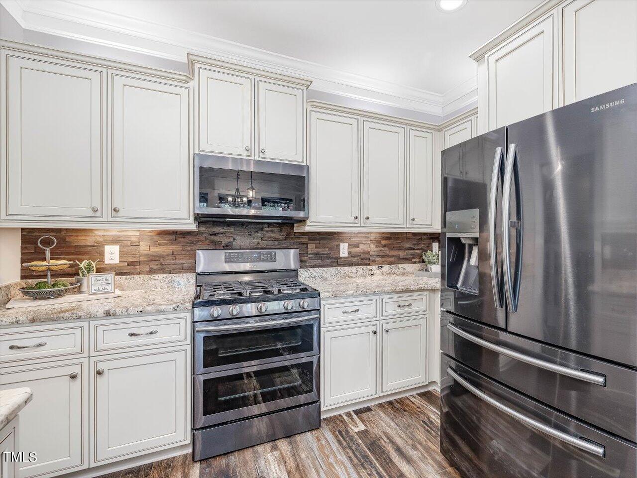 406 Gum Springs Church Road Moncure, NC 27559 - Photo 31 of 100 a kitchen with granite countertop white cabinets and stainless steel appliances