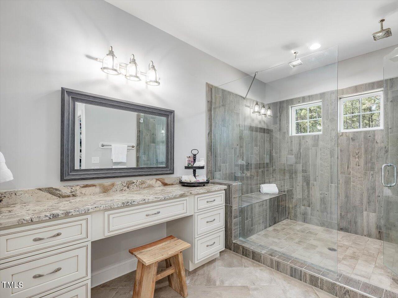 406 Gum Springs Church Road Moncure, NC 27559 - Photo 42 of 100 a bathroom with a granite countertop sink a toilet a mirror and shower
