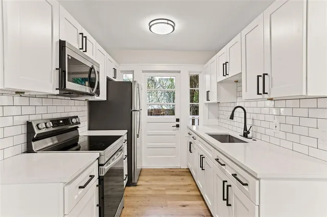 a kitchen with stainless steel appliances a stove sink microwave and cabinets