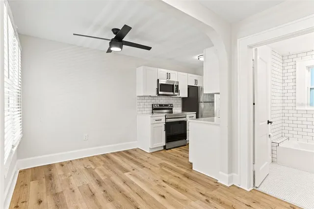 a kitchen with granite countertop a refrigerator and a stove top oven