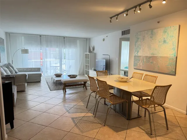 a living room with furniture a table and a large window