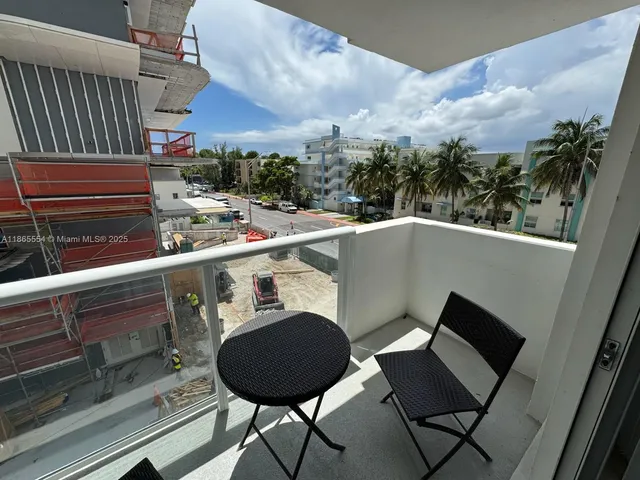 a view of a chairs and table in the balcony