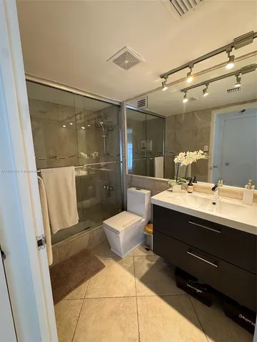 a bathroom with a sink mirror toilet and shower