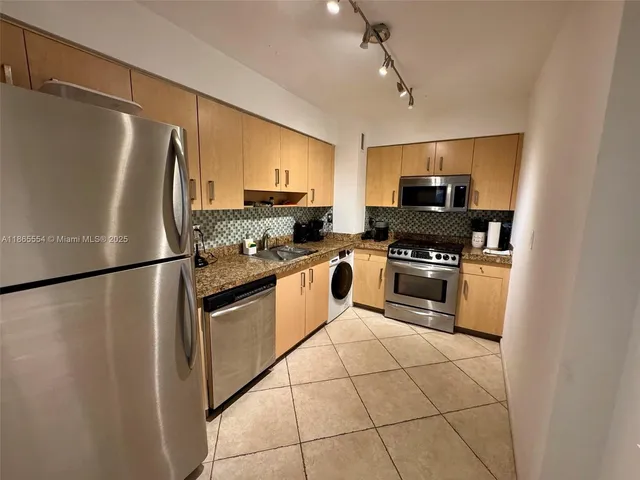 a kitchen with stainless steel appliances a refrigerator sink and microwave