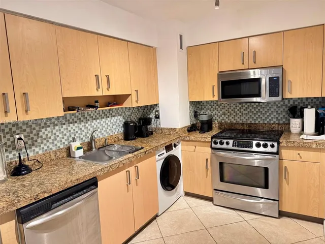 a kitchen with granite countertop a sink stove and cabinets
