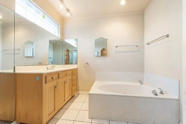 a spacious bathroom with a tub sink and mirror
