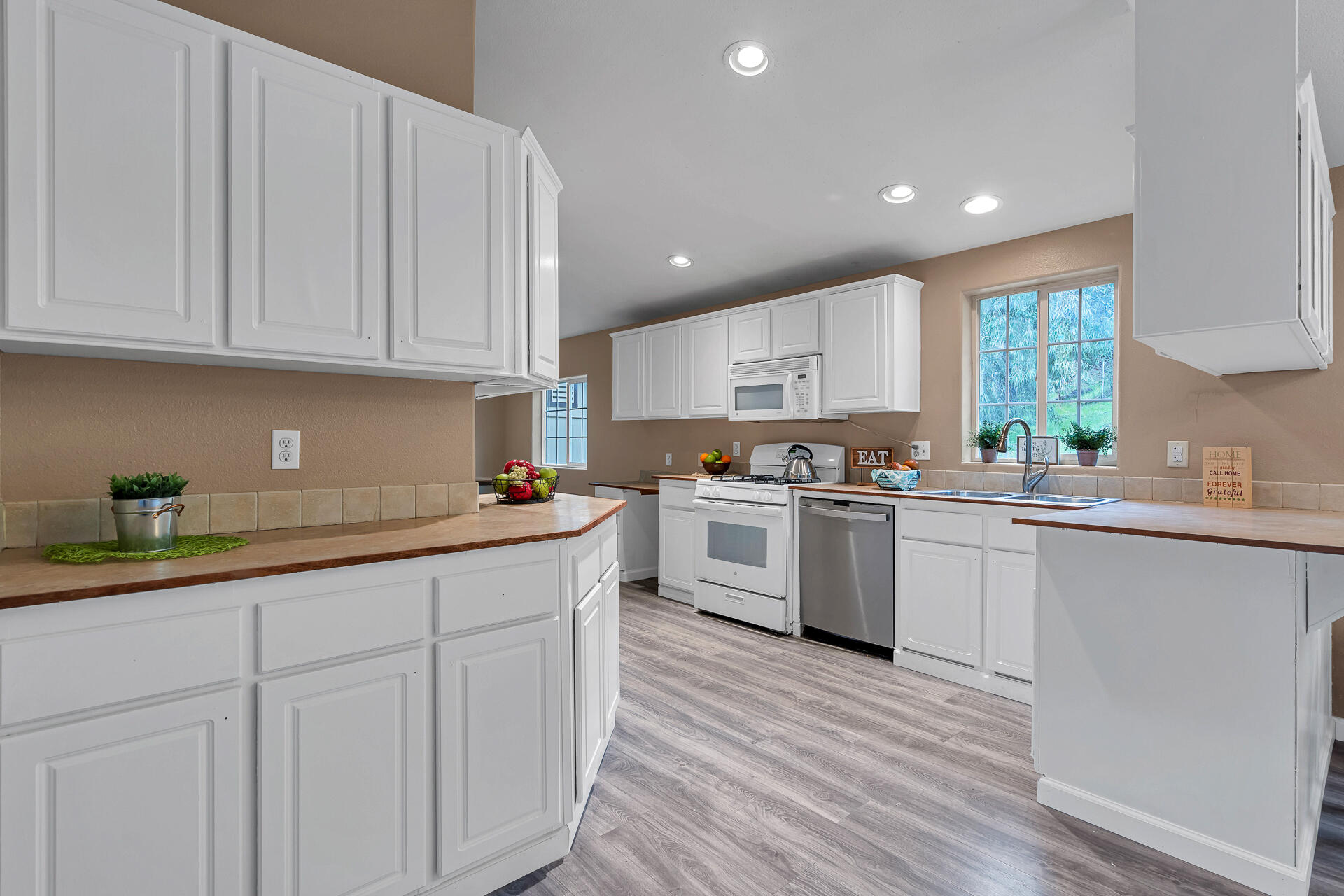 22150 Ravine Court Redding, CA 96003 - Photo 12 of 37 a kitchen with granite countertop white cabinets and white appliances
