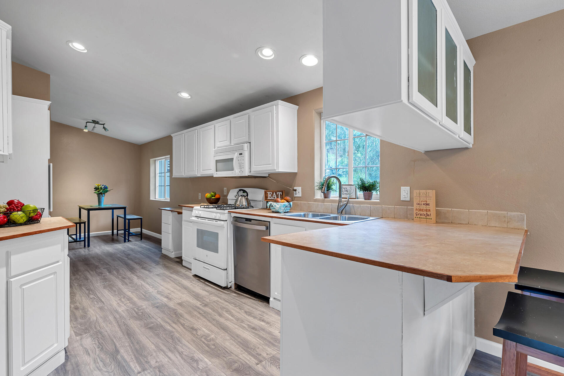 22150 Ravine Court Redding, CA 96003 - Photo 13 of 37 a kitchen with a sink cabinets and wooden floor