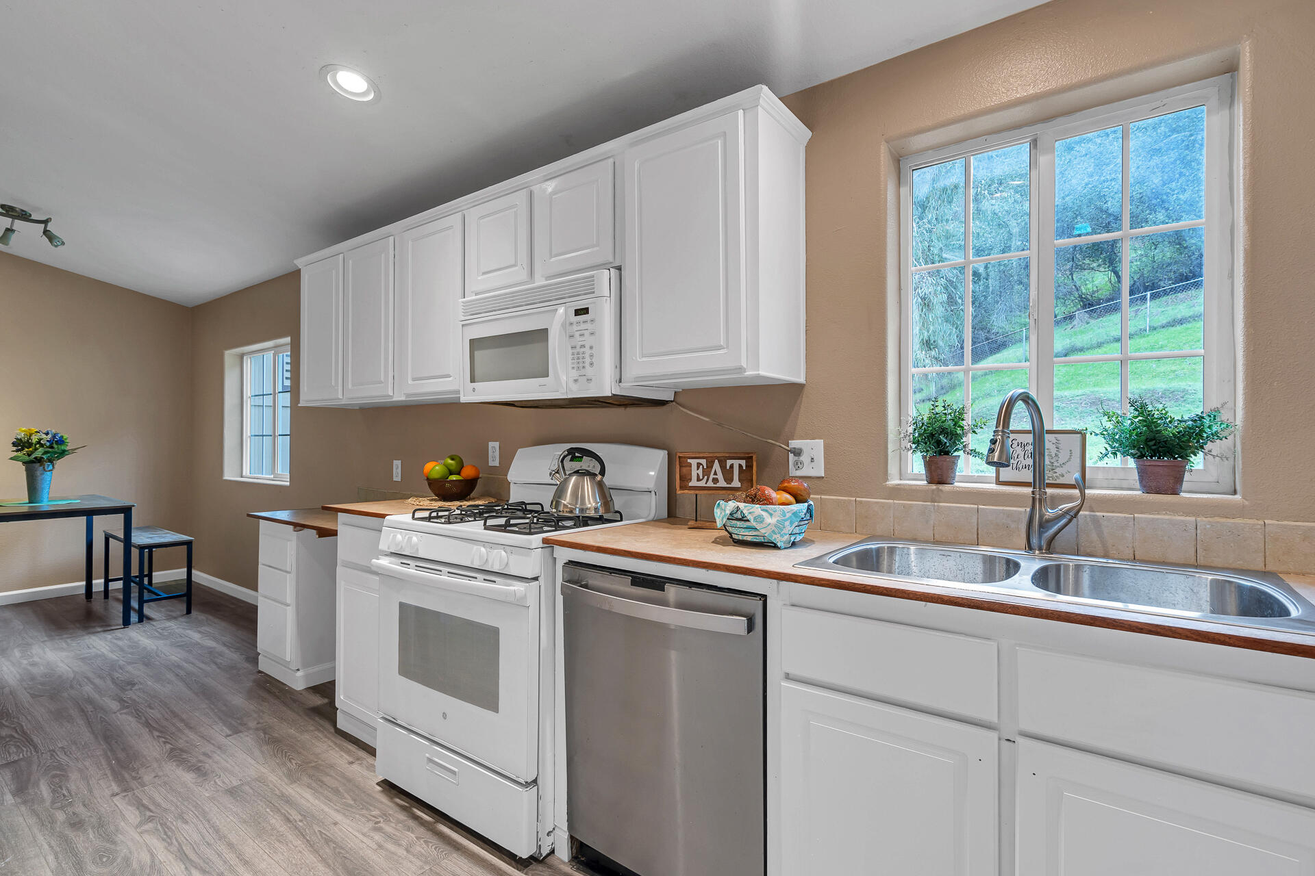 22150 Ravine Court Redding, CA 96003 - Photo 14 of 37 a kitchen with a sink white cabinets and white appliances