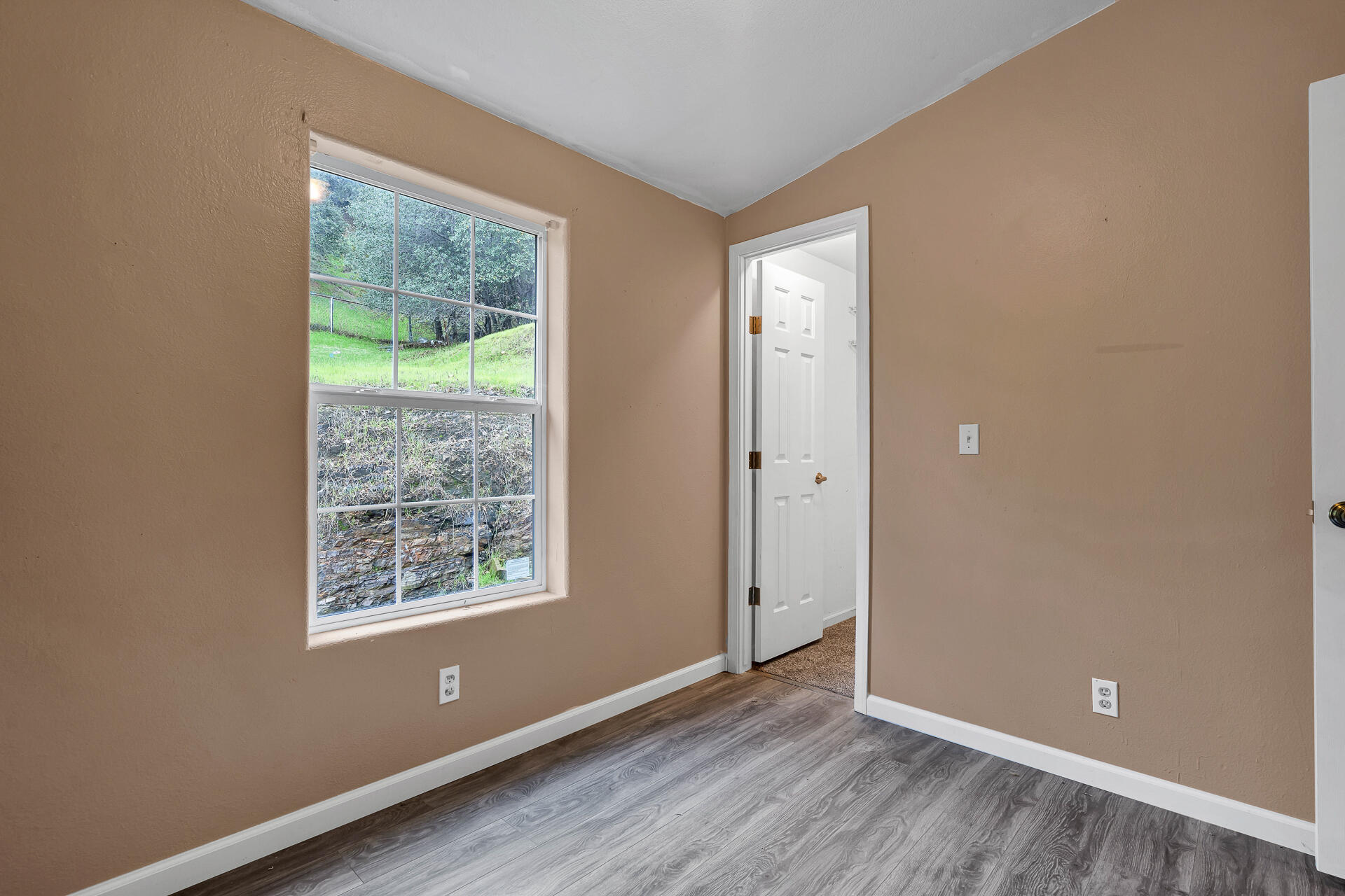 22150 Ravine Court Redding, CA 96003 - Photo 25 of 37 an empty room with wooden floor and windows