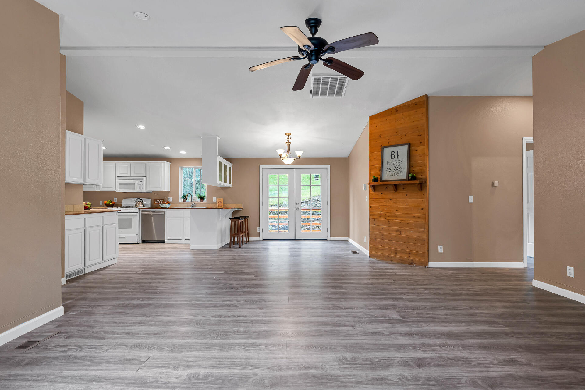 22150 Ravine Court Redding, CA 96003 - Photo 5 of 37 a view of an empty room and kitchen with wooden floor