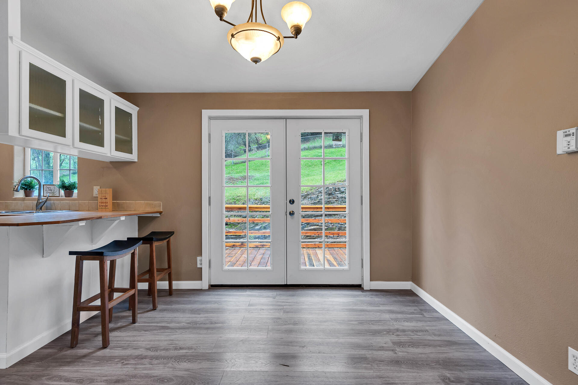 22150 Ravine Court Redding, CA 96003 - Photo 9 of 37 an empty room with wooden floor and windows
