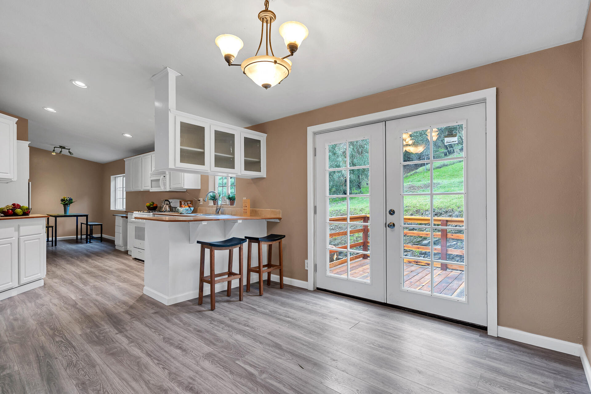 22150 Ravine Court Redding, CA 96003 - Photo 10 of 37 a open kitchen with stainless steel appliances granite countertop a stove top oven a large window with white cabinets and wooden floor
