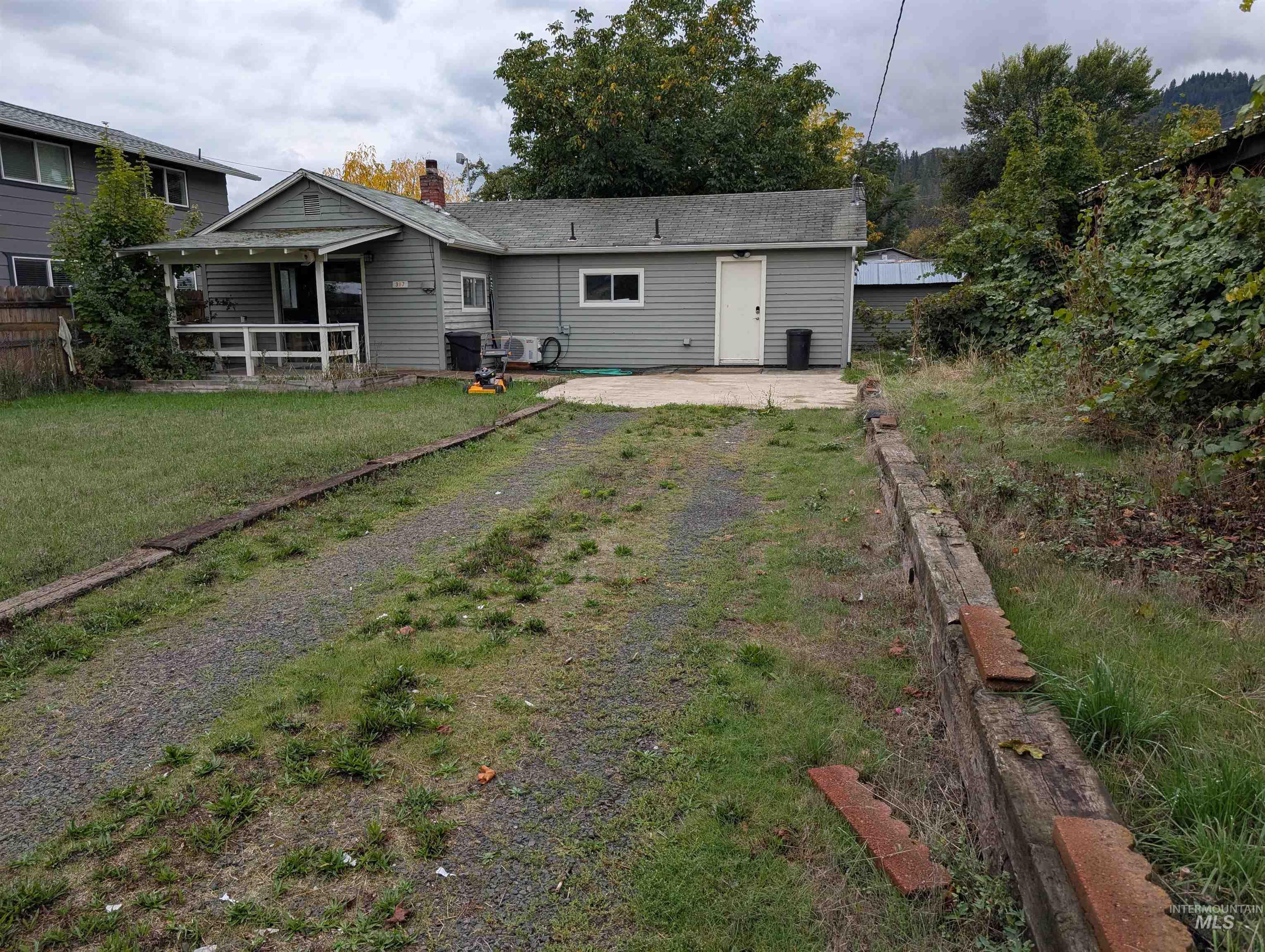 Back of property with a patio area, a chimney, and a lawn