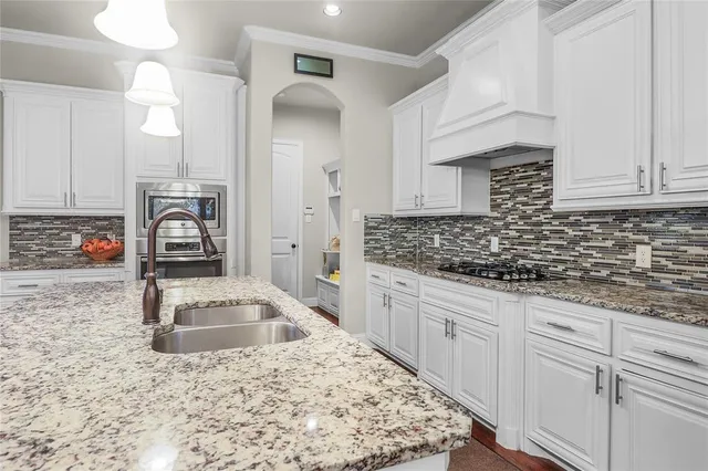 a kitchen with granite countertop white cabinets and white appliances