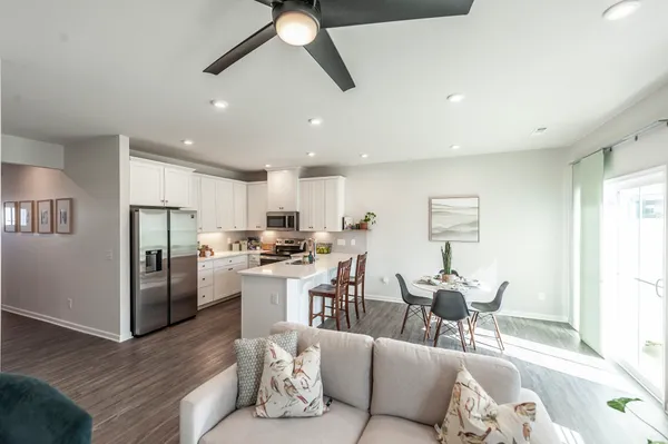 a living room with stainless steel appliances kitchen island granite countertop furniture and a refrigerator