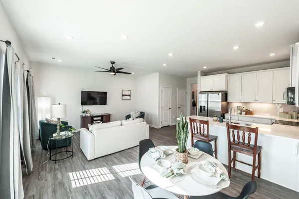 a living room with furniture kitchen view and a flat screen tv