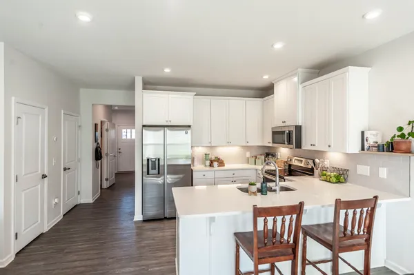 a dining room with stainless steel appliances a table and chairs