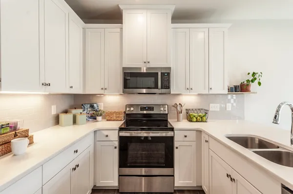 a kitchen with white cabinets and white appliances
