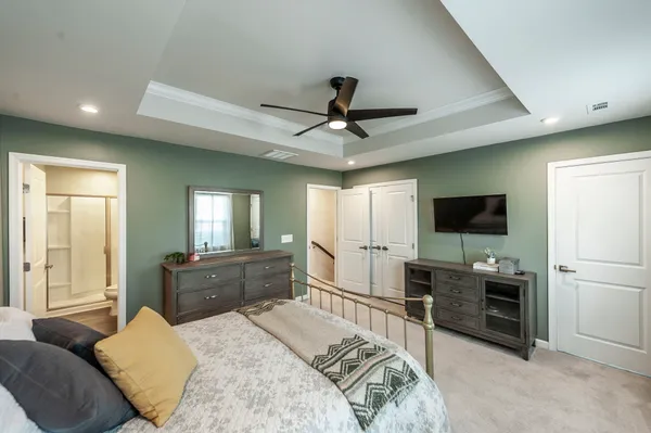 a large bedroom with a bed and a flat screen tv