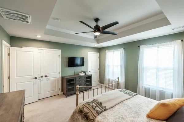 a spacious bedroom with a bed and a flat screen tv