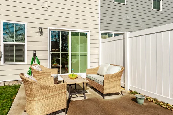 a living room with patio furniture and a potted plant