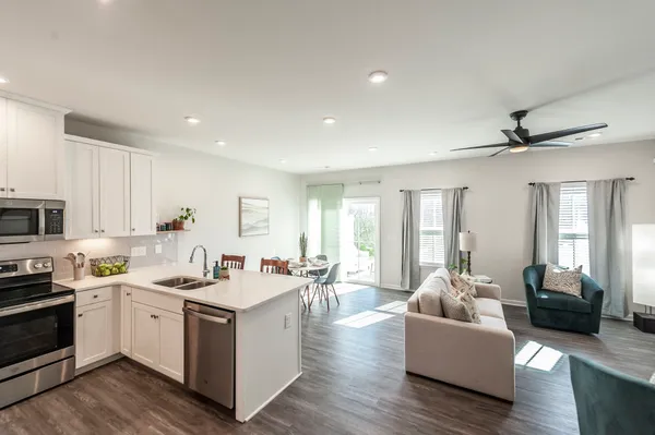 a view of living room kitchen with furniture and wooden floor