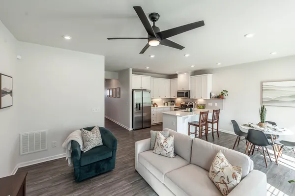 a living room with furniture white walls and kitchen view