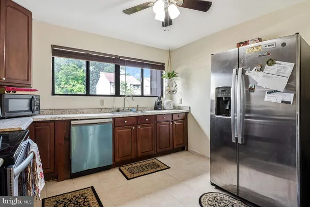 a kitchen with granite countertop a refrigerator and a sink