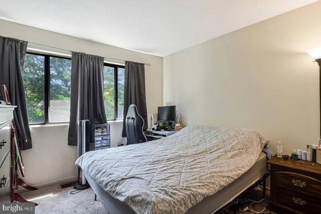 a bed sitting in a bedroom next to a window