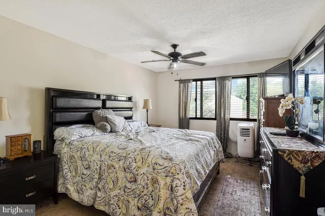a bedroom with a bed and large windows